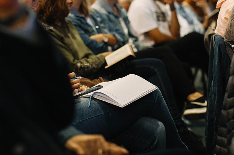 group of people with notebooks in their laps